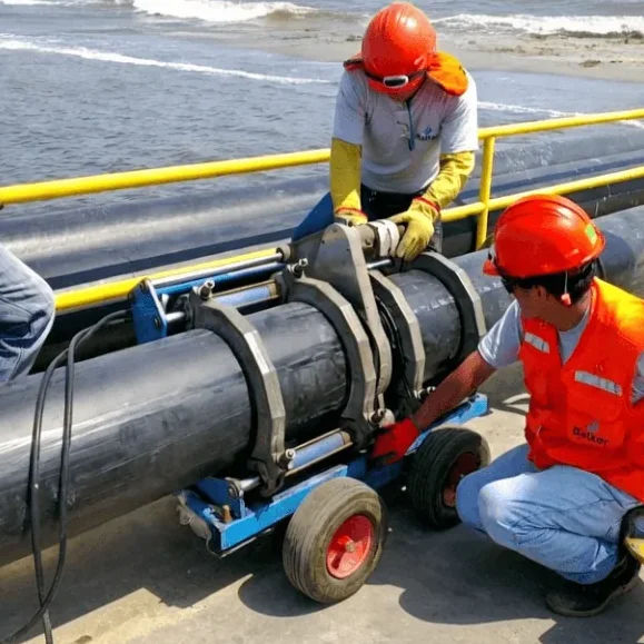 Máquina de termofusão em tubulação PEAD com operadores em campo